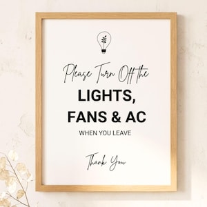 May include: A framed print with a light wood frame. The white background features black text that reads "Please Turn Off the LIGHTS, FANS & AC WHEN YOU LEAVE Thank You." A lightbulb graphic is at the top.