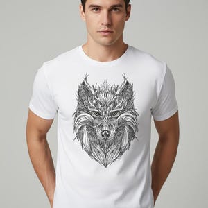 May include: White t-shirt with a detailed black and white illustration of a wolf's head. The artwork uses intricate line work, creating a textured design. The shirt is a classic crew neck style.