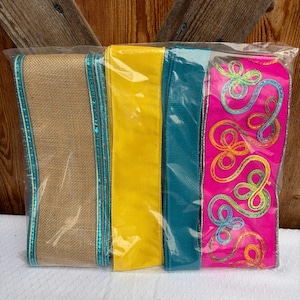May include: A package of decorative ribbons in various colors. The ribbons include burlap with teal trim, solid yellow, teal, and a vibrant pink ribbon with colorful embroidered swirls. The ribbons are packaged in clear plastic.