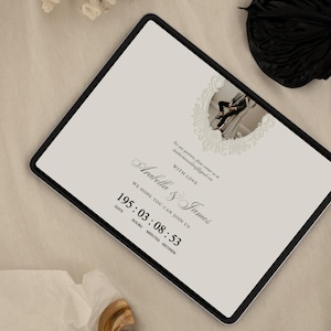K&ouml;nnte beinhalten: Ein digitales Tablet mit einer Hochzeitseinladung auf cremefarbenem Hintergrund, einem kreisf&ouml;rmigen Foto eines Paares in einem dekorativen Rahmen, dem Text: With love, Arabella & James, we hope you can join us, und einem Countdown-Timer mit 195:03:08:53.