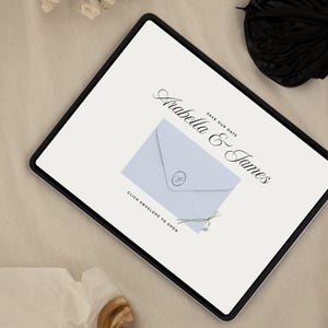 May include: A digital invitation on a tablet screen. The invitation features the names "Arabella & James" in elegant script, with "Save Our Date" above. A light blue envelope graphic is centered, with the text "Click Envelope to Open".