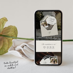 May include: A smartphone displays a wedding countdown app with the text "Kindly RSVP" and "The countdown is on!" The app shows photos and a timer. The phone is next to a white flower and the text "looks beautiful on mobile and desktop!"