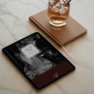 May include: A digital tablet displays a wedding invitation with the text "Save our Date" in a decorative frame. A brown leather-bound notebook and a glass of iced beverage sit nearby. The scene is set on a marble surface.