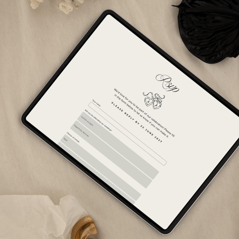 May include: A digital tablet displaying a wedding RSVP form. The form includes fields for name, attendance, and meal choices. The text "RSVP" is at the top, with the text "PLEASE REPLY BY 22 JUNE 2027" below the form. The tablet is on a neutral surface.