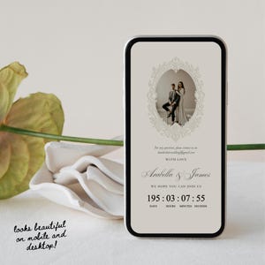 K&ouml;nnte beinhalten: Ein Smartphone zeigt eine digitale Hochzeitseinladung mit beigem Hintergrund, einem verzierten ovalen Rahmen mit einem Foto eines Paares und dem Text Arabella & James. Darunter zeigt ein Countdown 195 Tage, 03 Stunden, 07 Minuten und 55 Sekunden an.