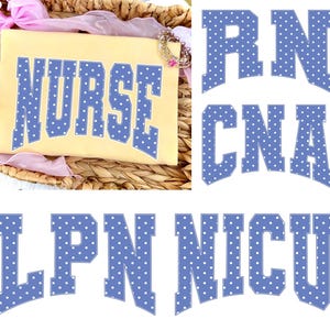 Könnte beinhalten: Ein hellgelbes T-Shirt mit dem Wort "NURSE" in großen, blau gepunkteten Buchstaben. Zusätzlicher Text enthält "RN", "CNA", "LPN" und "NICU" in ähnlichen blau gepunkteten Buchstaben. Das Shirt wird auf einem geflochtenen Korb präsentiert.