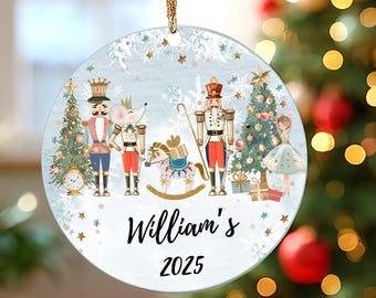 May include: Round Christmas ornament with a light blue background featuring a Nutcracker theme. The ornament has a gold string for hanging and includes the name "William's" and the year "2025". The design includes a Christmas tree, a mouse, and a ballerina.