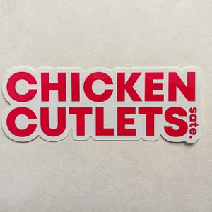 May include: A rectangular sticker with the words "CHICKEN CUTLETS" in bold red letters. The word "sate." is in smaller red letters on the right side. The sticker has a white border and is on a white background.