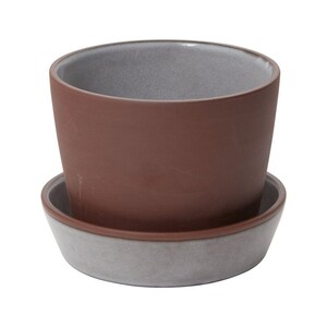 May include: A small, round terracotta-colored ceramic planter with a matching saucer. The interior of the planter and the rim of the saucer are a light gray color. The planter is designed for indoor or outdoor use.