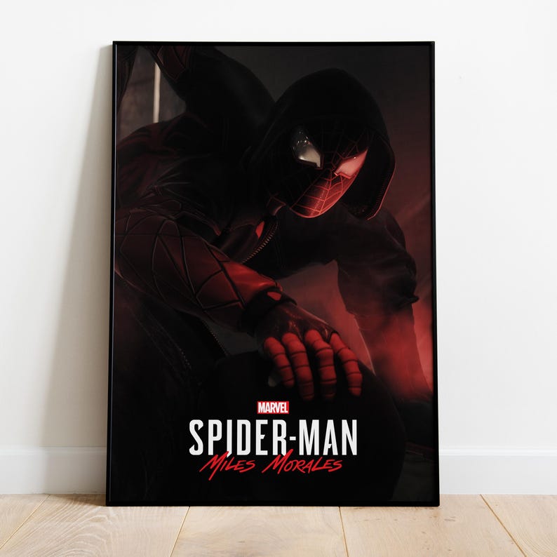 May include: A framed poster featuring Spider-Man, Miles Morales, in a dynamic pose. The artwork showcases the character in a black and red suit with a hooded jacket. The Marvel logo and the title "Spider-Man: Miles Morales" are prominently displayed in white.