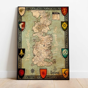May include: A framed map of Westeros, featuring a detailed geographical layout with labeled locations and surrounding seas. The map is in a vintage style, with a light green background and brown details. Shields with various emblems are placed around the map's border.