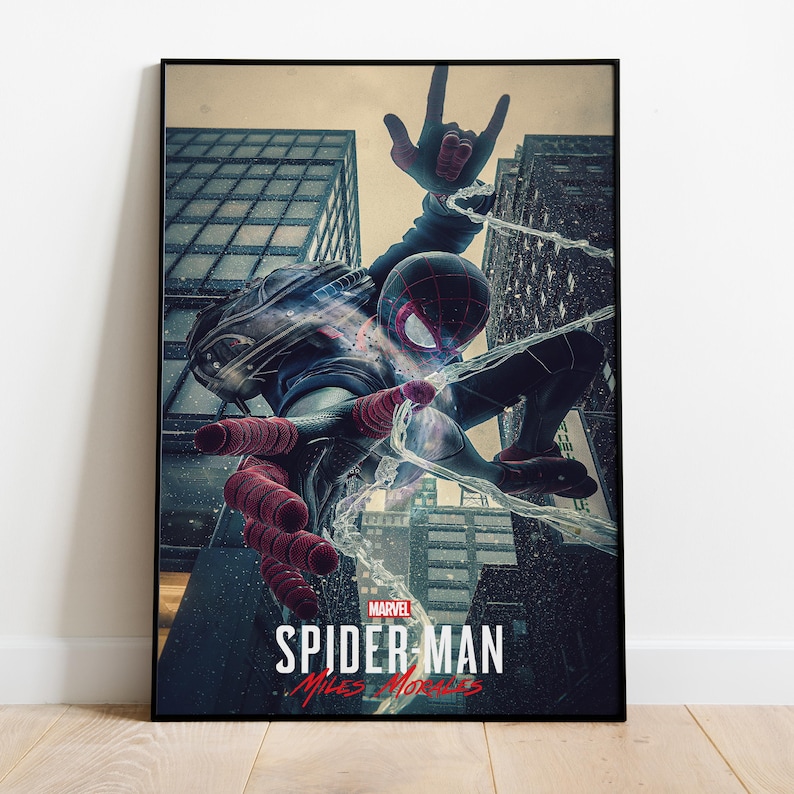 May include: Framed poster featuring Spider-Man in a dynamic pose amidst city skyscrapers. The artwork showcases Spider-Man in a black and red suit, with web-slinging action. The Marvel logo and "Spider-Man: Miles Morales" text are visible.