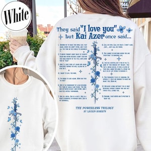 Op de afbeelding: Witte sweatshirt met de blauwe tekst "They said 'I love you' but Kai Azer once said...". Een zwaardontwerp met blauwe rozen en vlinders staat op de achterkant. "The Powerless Trilogy" van Lauren Roberts is ook gedrukt.