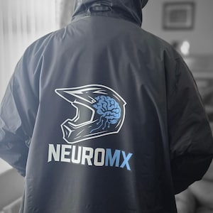 Puede incluir: Chaqueta negra con capucha con el texto "NEUROMX" en blanco y azul claro. La chaqueta presenta un gráfico blanco y azul de un cerebro dentro de un casco de moto.