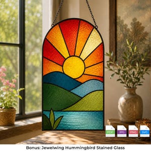 May include: An arched stained glass suncatcher featuring a vibrant yellow sun rising over blue and green rolling hills and a calm blue lake. The design includes red, orange, and yellow sun rays, all encased in a black metal frame with a hanging chain.