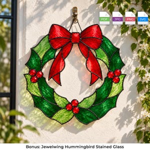 May include: A stained glass wreath featuring vibrant green holly leaves and bright red berries, accented with a large red bow at the top. The circular design is constructed with dark metal lead lines and hangs from a metal hook on a wall.