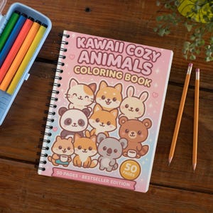 May include: A spiral-bound coloring book titled "Kawaii Cozy Animals Coloring Book" with illustrations of cute animals. The book is pink and white with a blue pencil case and pencils on a wooden surface.