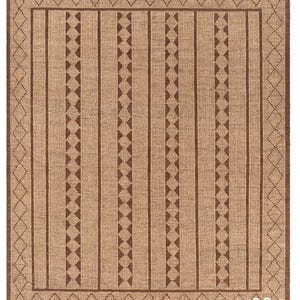 May include: A rectangular woven rug with a natural beige background and brown geometric patterns. The design includes vertical stripes, triangles, and diamond shapes, with a fringed edge. The rug is suitable for indoor use.
