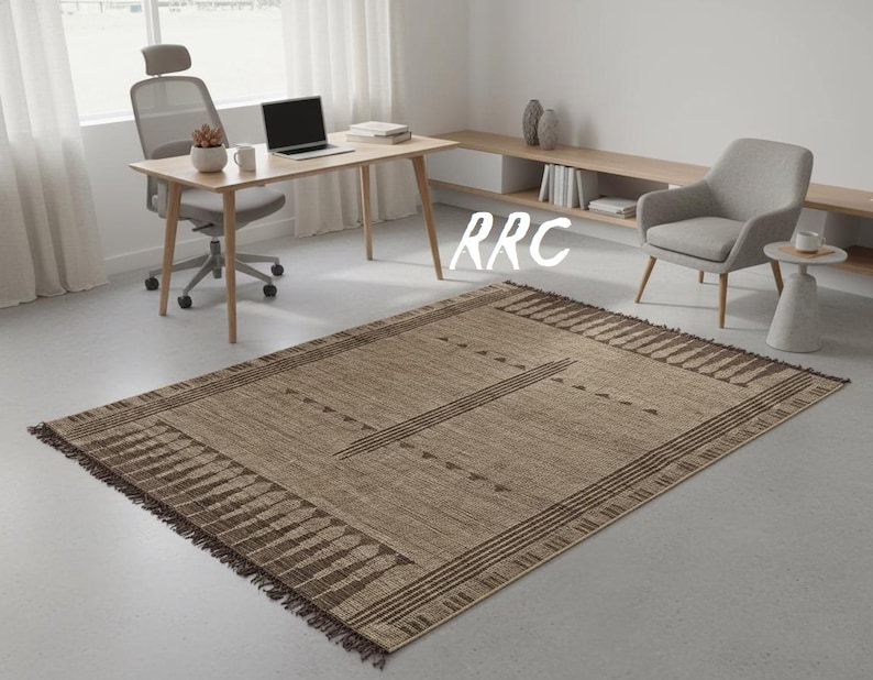 "Handmade Tuareg rug made of woven jute and brown leather strips with geometric tribal patterns and fringe details laid out on the floor."