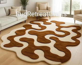 Puede incluir: Una alfombra grande y abstracta con un fondo crema y formas orgánicas fluidas en tonos marrones. La alfombra está colocada sobre un suelo de madera clara. El texto "RugRetreatCrafts" es visible.