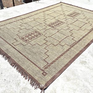 Sustainable handmade jute area rug with leather fringe and tribal motifs for warm natural home decor