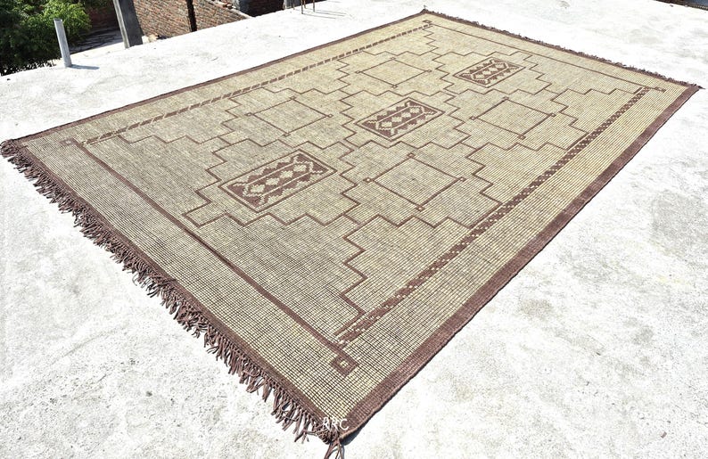 Sustainable handmade jute area rug with leather fringe and tribal motifs for warm natural home decor