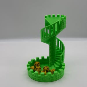 May include: A bright green dice tower with a spiral staircase design. The tower has a circular base and a crenelated top. Several yellow dice with black numbers are inside the base.