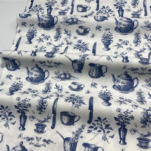 Può includere: Tessuto bianco con un motivo blu toile de Jouy con teiere, tazze, coltelli e composizioni floreali. Il design include illustrazioni dettagliate di vari elementi della cucina e della sala da pranzo, creando un'estetica classica e decorativa.