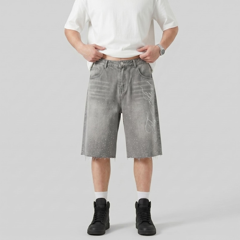 May include: Gray denim shorts with a raw hem and white accents. The shorts have a relaxed fit and feature a faded design. The shorts are paired with black high-top sneakers.