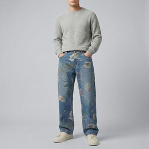 May include: A person wearing a light gray crew neck sweater and blue denim jeans with a floral pattern. The person is also wearing white sneakers. The jeans have a relaxed fit.