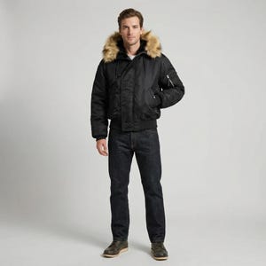 K&ouml;nnte beinhalten: Schwarze Bomberjacke mit Kapuze mit Kunstfellfutter. Die Jacke hat einen Rei&szlig;verschluss, mehrere Taschen sowie gerippte B&uuml;ndchen und Saum. Die Person tr&auml;gt dunkelblaue Jeans und braune Schuhe.