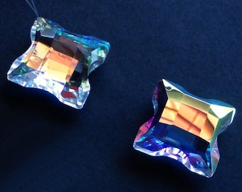 May include: Two iridescent crystal butterfly charms with a faceted design. The charms are clear with rainbow colors and have a hole at the top for hanging.