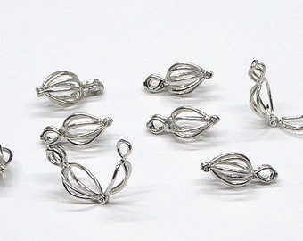 May include: A set of eight silver-toned metal clasps for jewelry making. The clasps are designed to hold a pearl or other round bead.