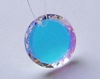 May include: A turquoise blue crystal pendant with a clear iridescent border. The pendant is round and has a hole at the top for hanging.