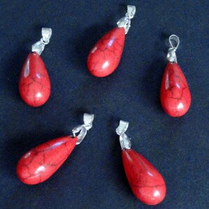 May include: Five red teardrop-shaped pendants with silver bail loops. The pendants are made of red jasper or red agate.