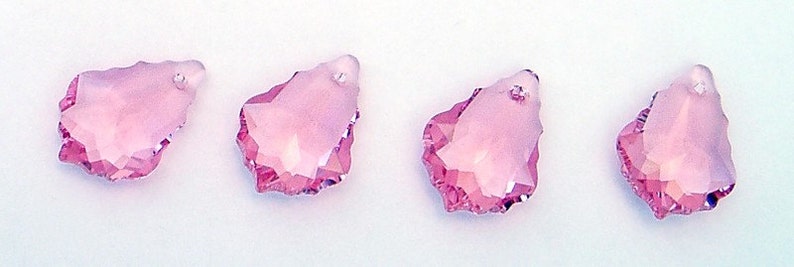 Puede incluir: Cuatro colgantes de cristal rosa en forma de l&aacute;grima con bordes facetados.
