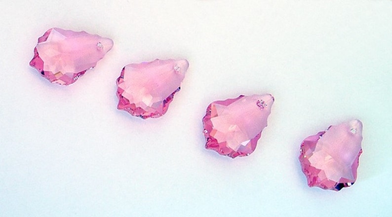 Puede incluir: Cuatro colgantes de cristal rosa en forma de l&aacute;grima con bordes facetados.