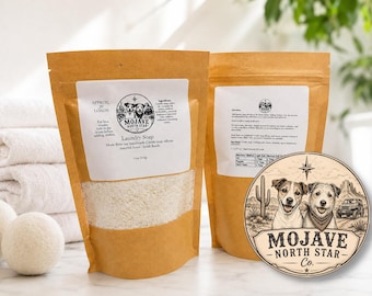 Puede incluir: Dos bolsas de papel marrón de detergente Mojave North Star Co. con etiquetas blancas e ilustraciones de perros. La etiqueta indica los ingredientes y un peso de 312g. Una pegatina circular con un paisaje desértico se sitúa delante.
