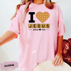 A person wearing a pink t-shirt with a heart-shaped waffle and the text "I ♥ JESUS" printed on it.