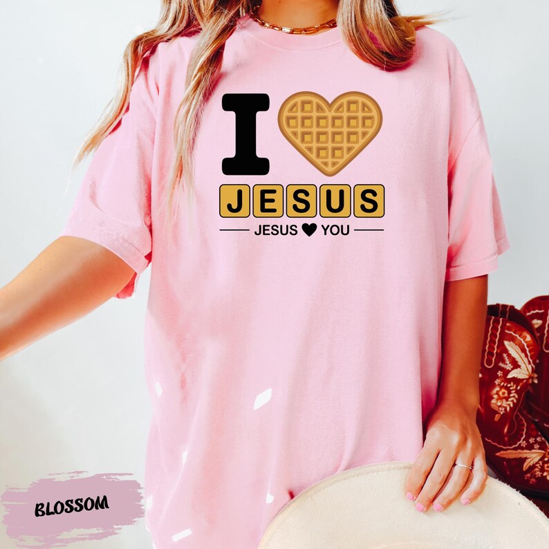 A person wearing a pink t-shirt with a heart-shaped waffle and the text "I ♥ JESUS" printed on it.