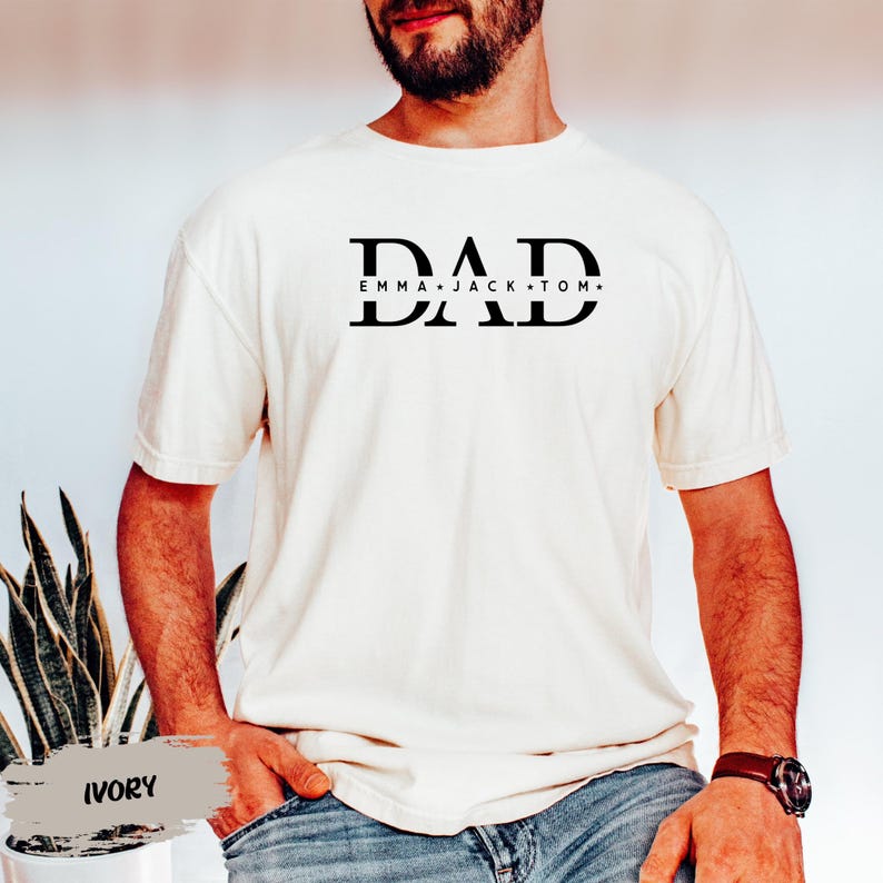 A man wearing a white t-shirt with the text "DAD Emma Jack Tom" printed on it.