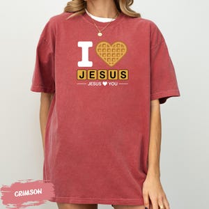 A red t-shirt with a graphic design that says "I ❤️ JESUS ❤️ YOU" along with a heart-shaped waffle icon.