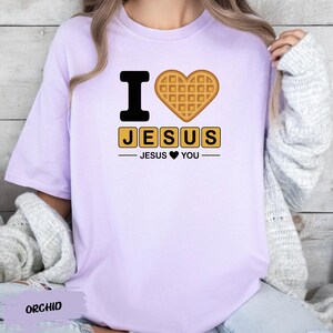 A person wearing a purple t-shirt with a heart-shaped waffle and the text "I ♥ JESUS" printed on it.
