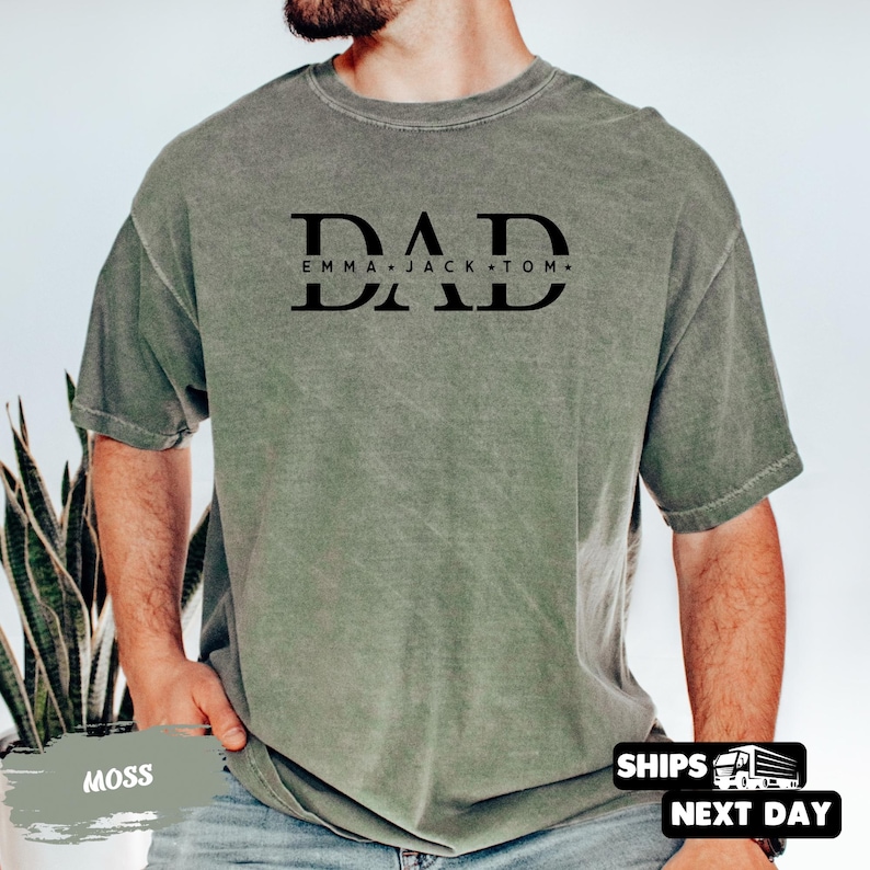 A man wearing a green t-shirt with the text "DAD Emma Jack Tom" printed on it.