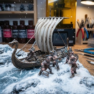 Op de afbeelding: Een gedetailleerde miniatuur Viking-langschip met een crèmekleurig zeil en een boeg in de vorm van een drakenkop. Het schip is bevolkt met verschillende krijgersfiguren, tegen een besneeuwde, ijzige achtergrond. De scène roept een gevoel van avontuur en historische fantasie op.