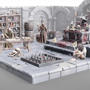 May include: A miniature dungeon diorama featuring a stone room with a bookshelf, a wooden table, and a spiked floor pit. It includes figures of a hooded scholar, a torch-bearing figure, a chained prisoner, and a robed figure at a blood-stained altar.