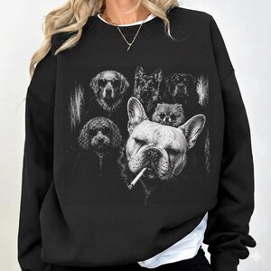 May include: A black crewneck sweatshirt featuring a detailed white graphic print of several dog breeds. The central image depicts a French Bulldog with a cigarette in its mouth, surrounded by other dogs including a Golden Retriever and a German Shepherd.