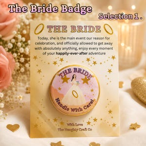 May include: A circular pin-back button featuring an illustration of a person in a white gown, gold stars, and the text THE BRIDE Handle With Care. It is mounted on a rectangular card with the text THE BRIDE and a celebratory message.