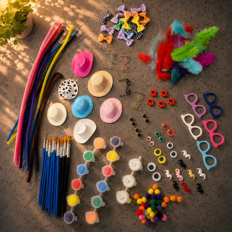May include: A craft supply kit featuring colorful pipe cleaners, miniature hats in various colors and patterns, small bows, feathers, paintbrushes, paint pots, googly eyes, plastic glasses frames, and small pom-poms arranged on a flat surface.