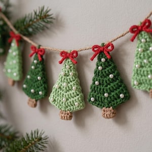 May include: A festive garland featuring alternating light and dark green crocheted Christmas tree ornaments. Each tree is topped with a small red yarn bow and decorated with tiny white pearl beads, all strung together on a natural jute twine cord.